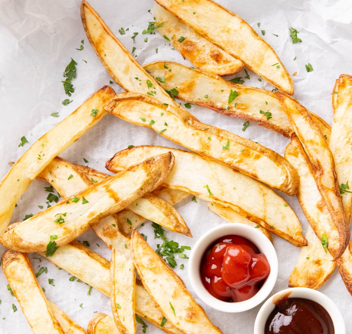 Crisped, not fried potatoes in crinkled parchment served with ketchup and barbecue sauce