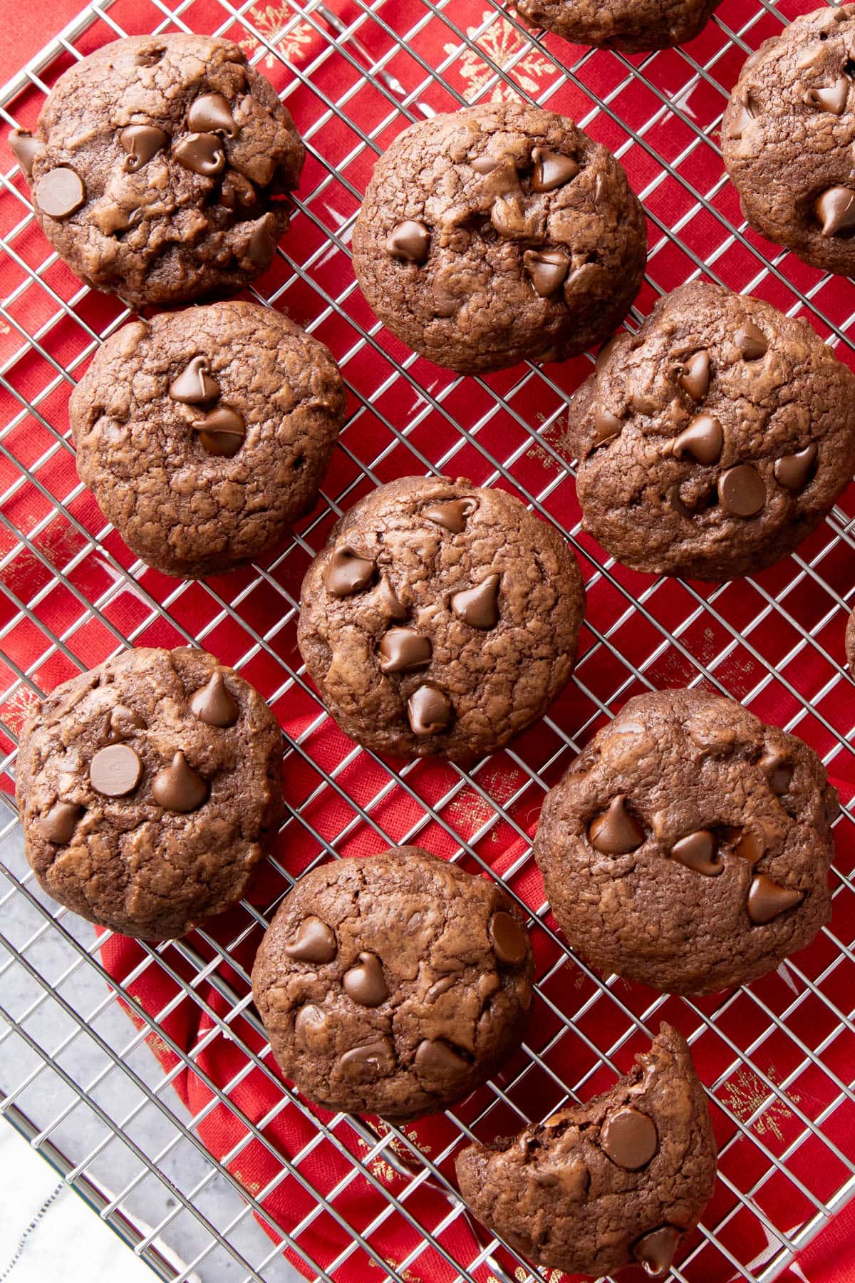 Overhead shot of brownie cookies cooling on a rack with melted chocolate chips