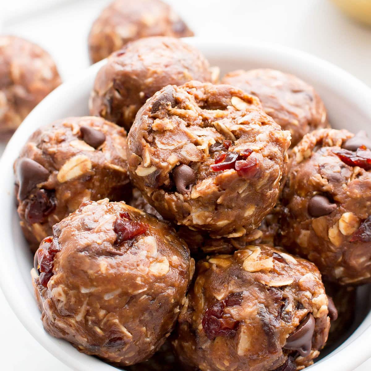 Bowl of chocolate energy balls with one bitten in the center