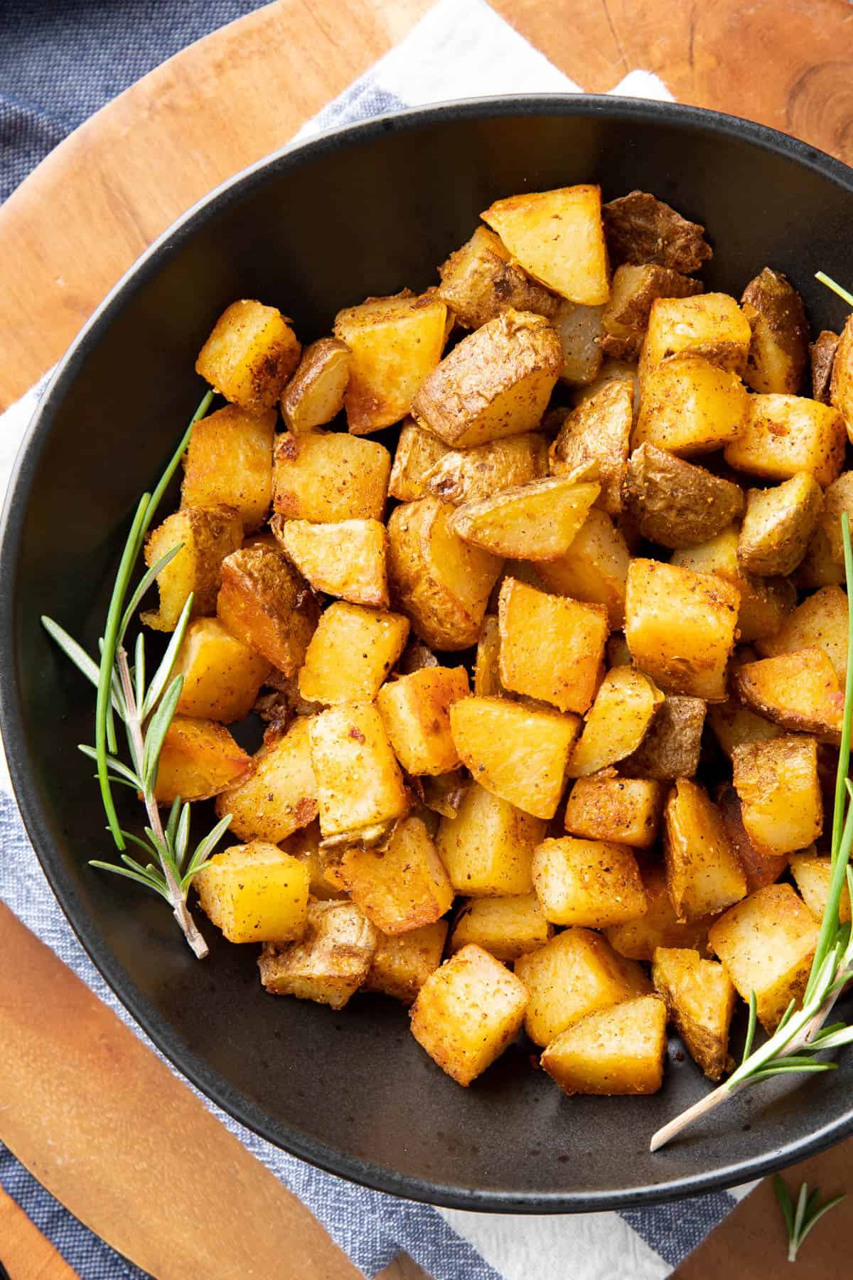 Black serving bowl full of Crispy Breakfast Potatoes