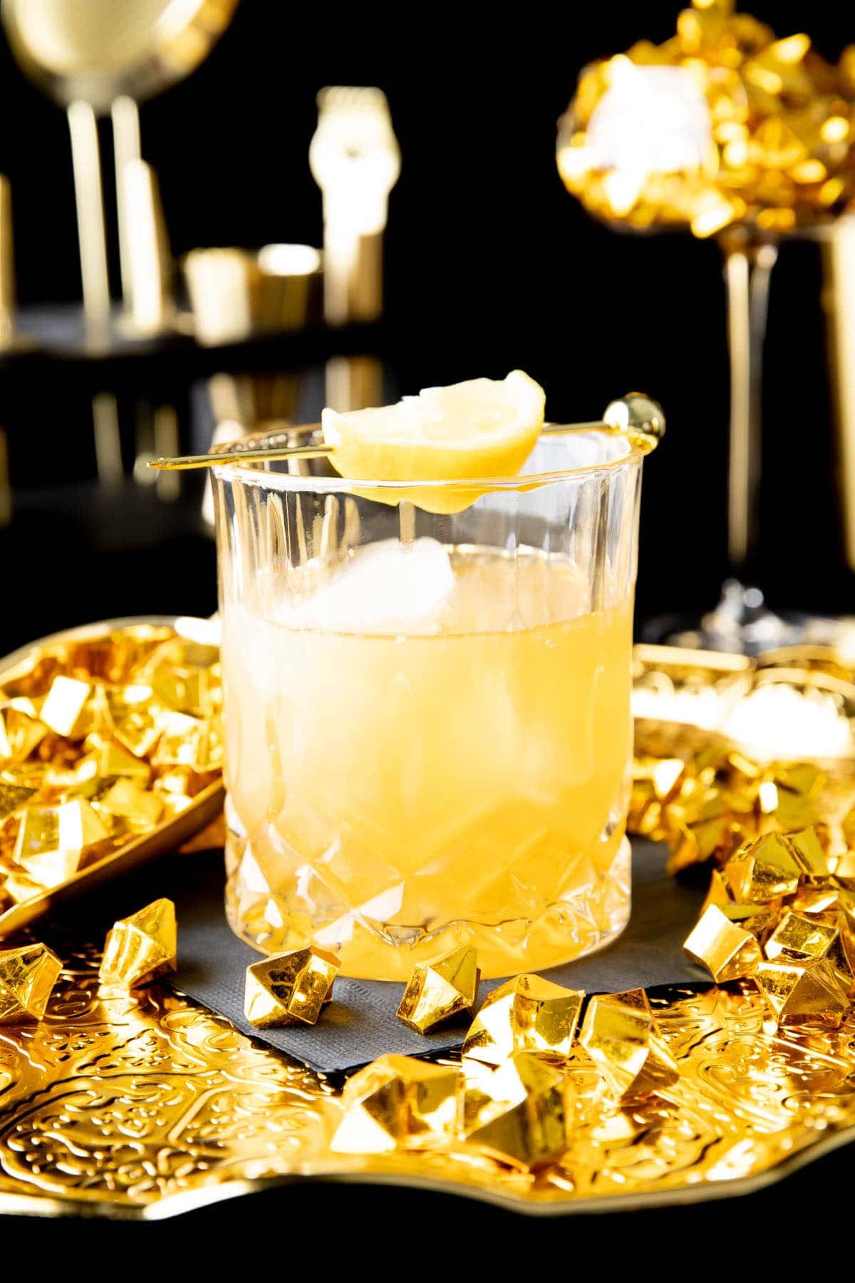 Gold Rush Cocktail served in an old fashioned glass with a lemon garnish
