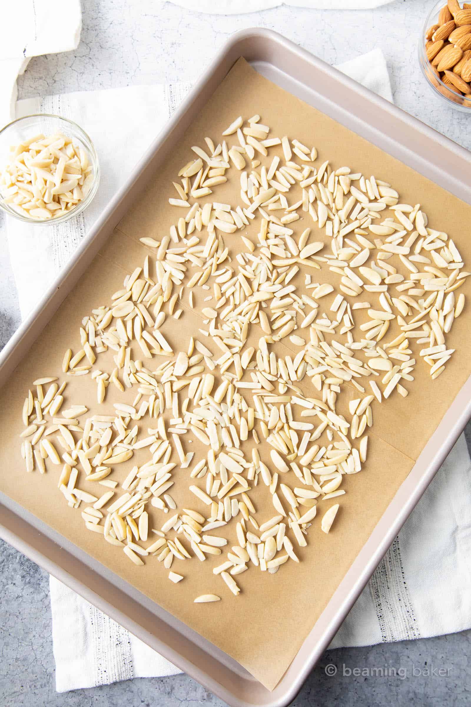 untoasted slivered almonds on parchment paper