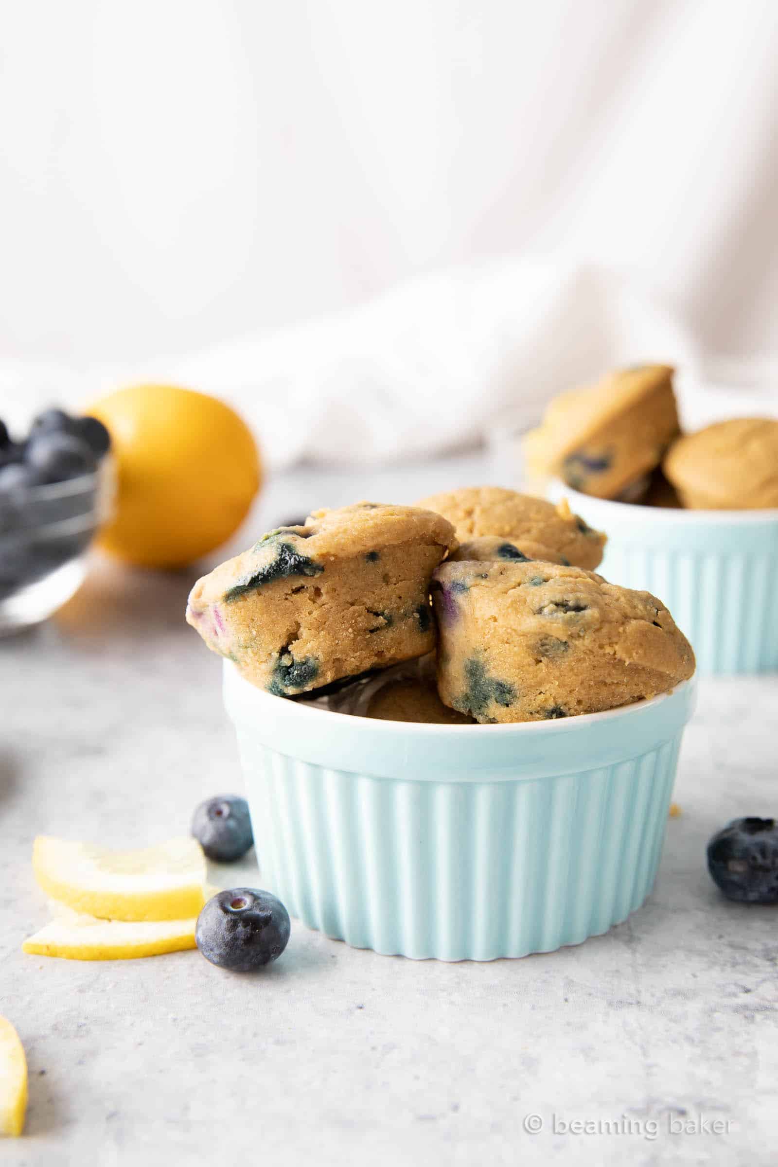 Mini Vegan Lemon Blueberry Muffins: super cute, mini-sized moist vegan lemon blueberry muffins. Bright blueberry & fresh lemon flavor packed into tiny vegan muffins! #Vegan #Lemon #Blueberry #Muffins | Recipe at BeamingBaker.com