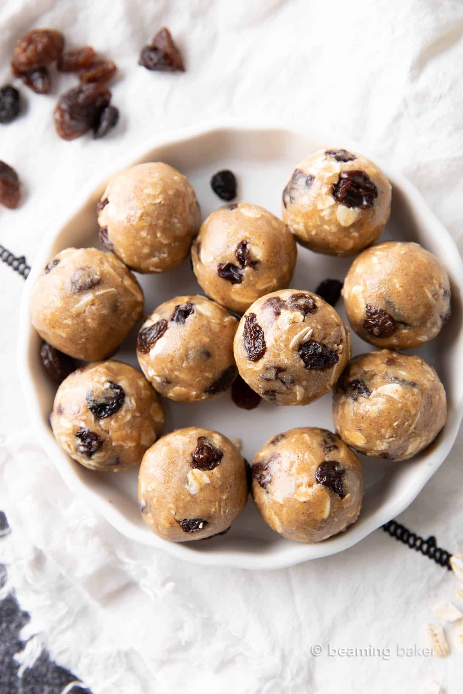 medium close stack of oatmeal raisin bites on a plate with oats and raisins