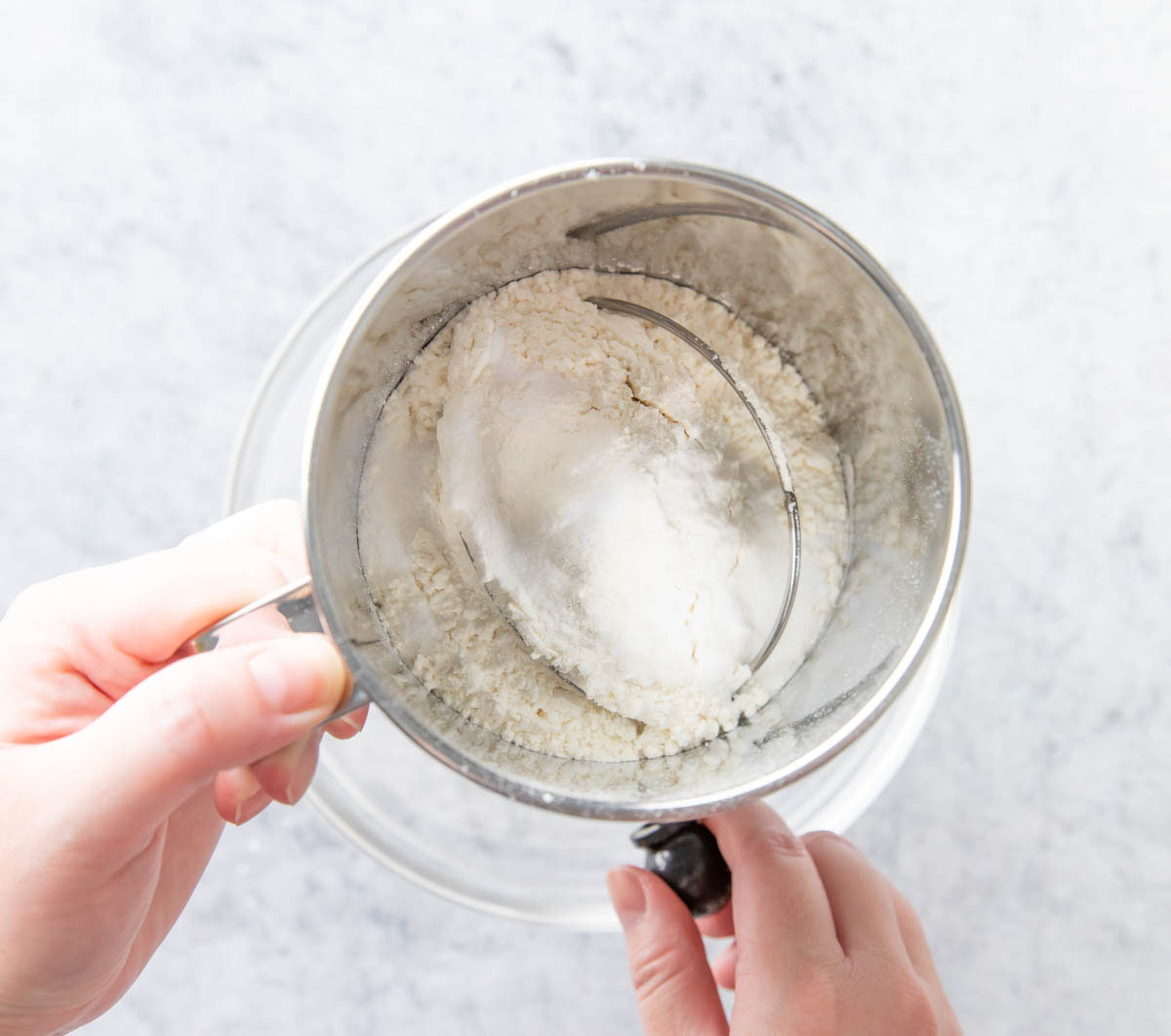 Sifting dry ingredients including flour, baking soda, and salt to make the peanut butter blondies dough