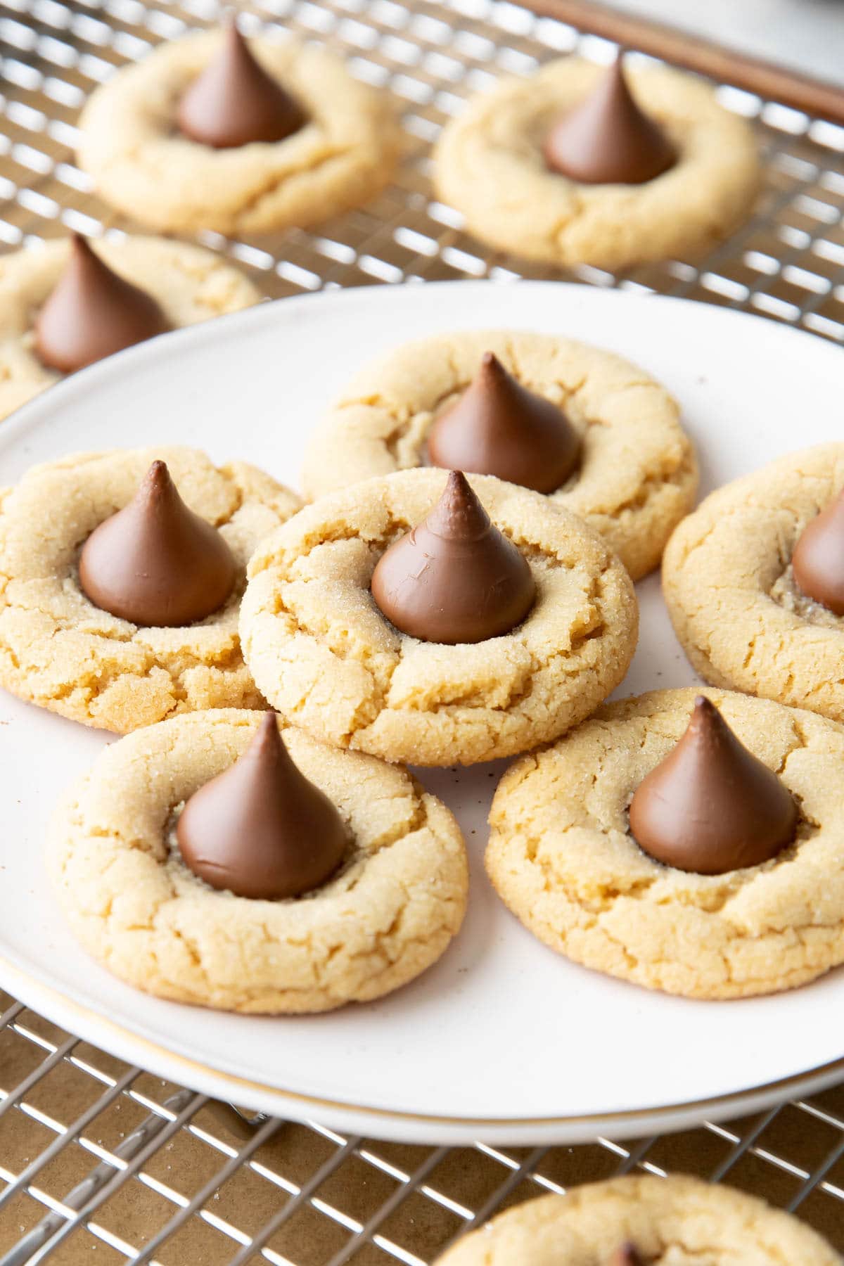 Close up of peanut butter blossoms on in a stack on a white plate