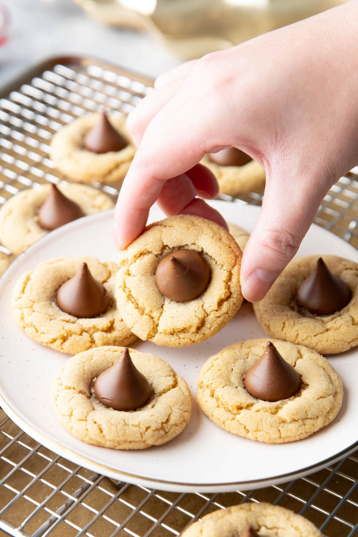 Hand picking up a chewy cookie from a plate