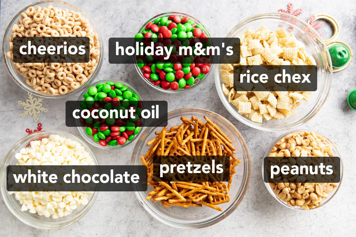  Bowls of pretzels, rice Chex, cheerios, peanuts, red and green holiday M&M’s candies, and white chocolate morsels to make Christmas puppy chow