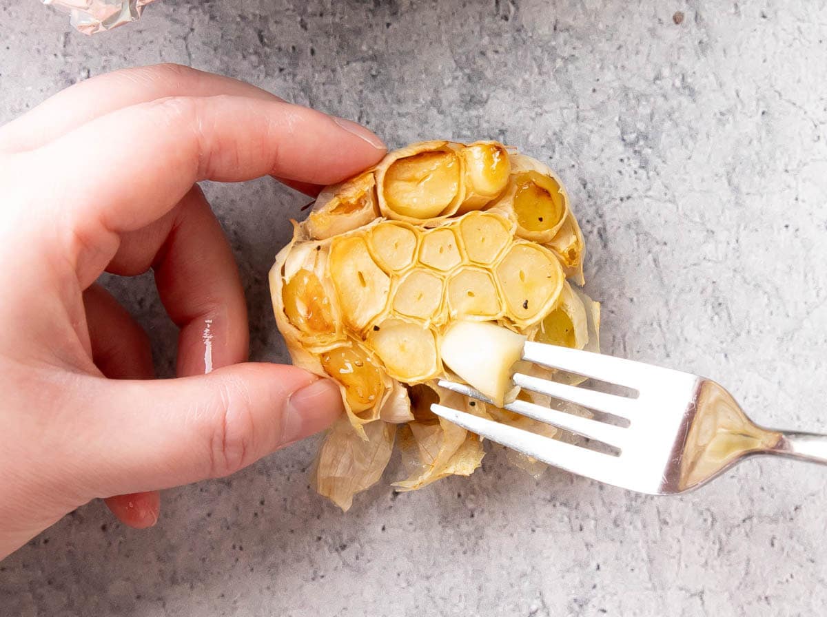 Two photos showing How to Make Roasted Garlic Bread – removing the garlic cloves