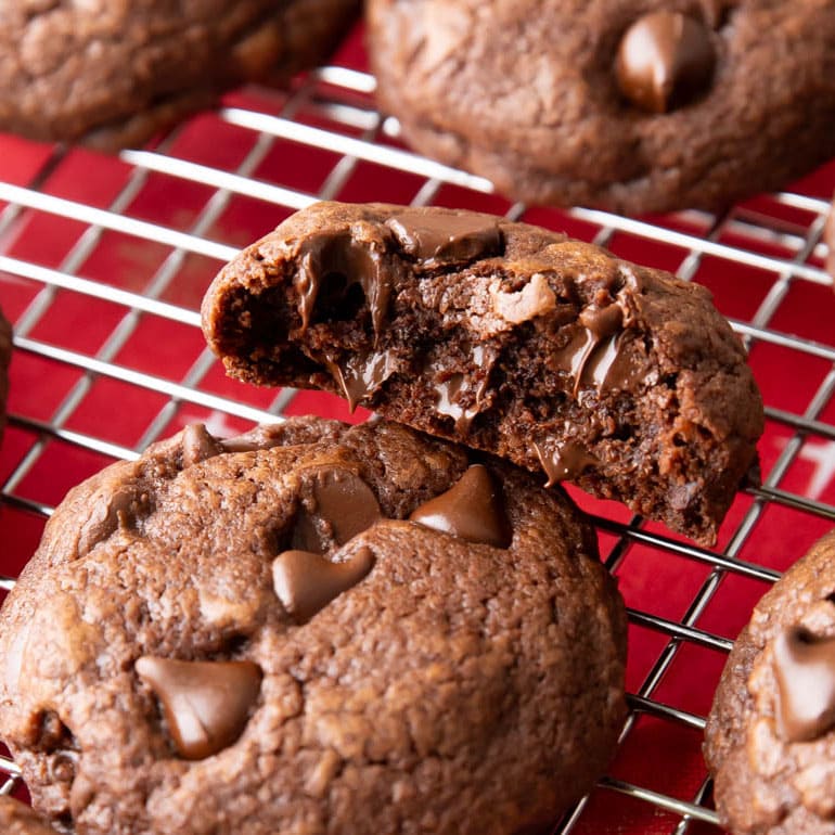 Close up of a bitten baked good with fudgy, moist centers and melted chocolate chips oozing out