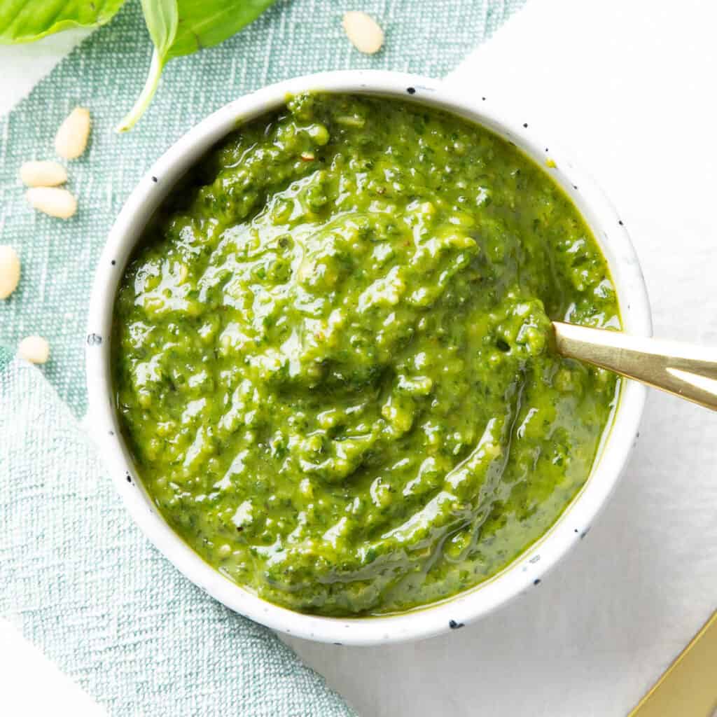 Vegan pesto in a white bowl with a spoon