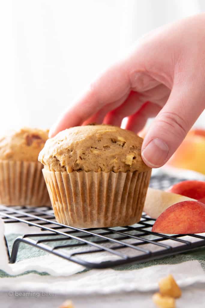 Hand reaching for vegan apple muffin